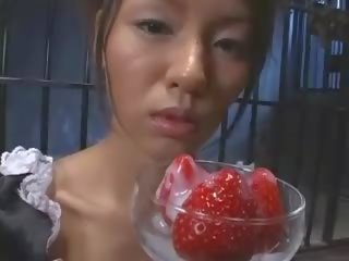 جميل الآسيوية في سن المراهقة مصنوع يأكل strawberries مع نطفة غطاء
