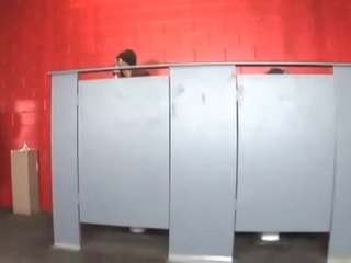 Dois bêbeda amigos ações um negra acompanhante em banheiro