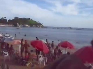 Casal trepando na praia.